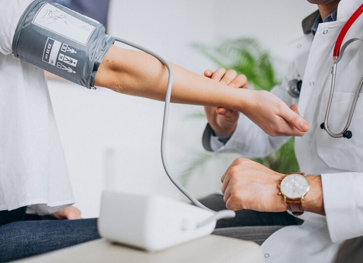 young-male-psysician-with-patient-measuring-blood-pressure